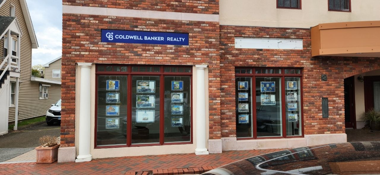 Coldwell Banker storefront with building sign and window graphics